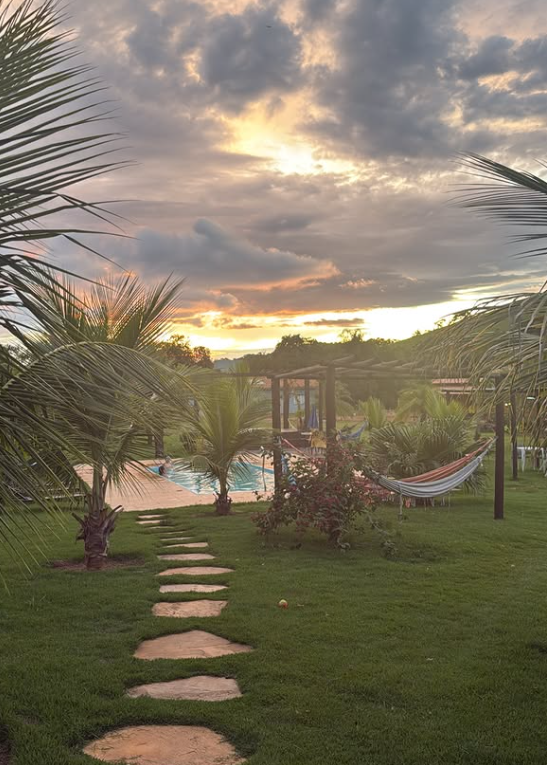 Jardim, redes e piscina ao entardecer